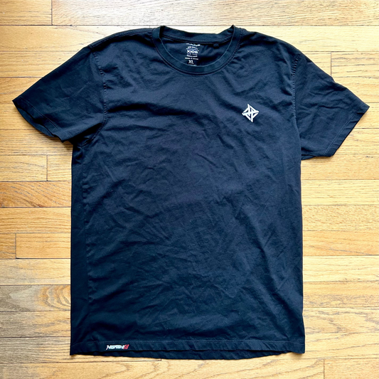 A navy-colored, crew-neck t-shirt laid flat on a wooden surface.